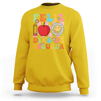Yellow sweatshirt with colorful Feliz 100 Days of School graphic, apple, pencil, and flower
