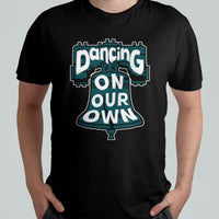 Black crew-neck T-shirt worn by model, featuring colorful "Dancing On Our Own" graphic.