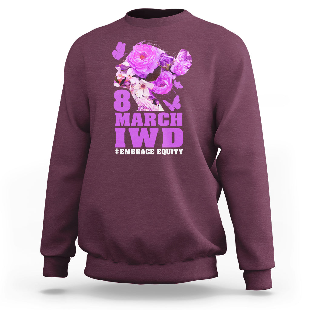 Maroon women’s sweatshirt with floral IWD graphic and text #EMBRACE EQUITY on front