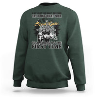 Forest green crewneck sweatshirt with back graphic print and compass-style design.