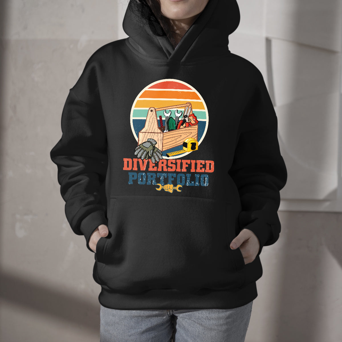 Black hoodie with front Diversified Portfolio logo and colorful tool illustration
