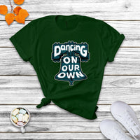 Green crew-neck T-shirt with colorful "Dancing On Our Own" graphic front.