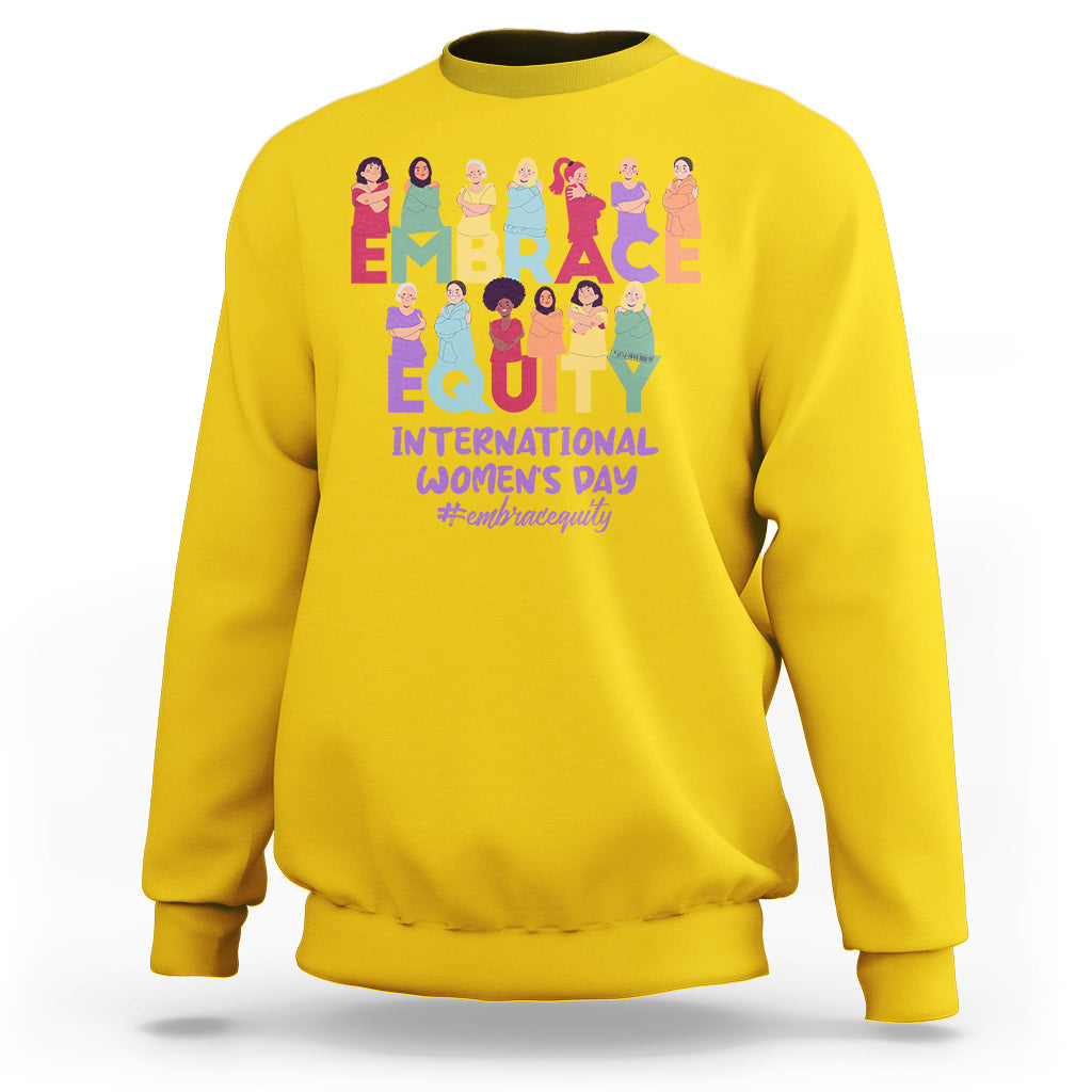 Daisy yellow crewneck sweatshirt with colorful “EMBRACE EQUITY” women’s day graphic on back