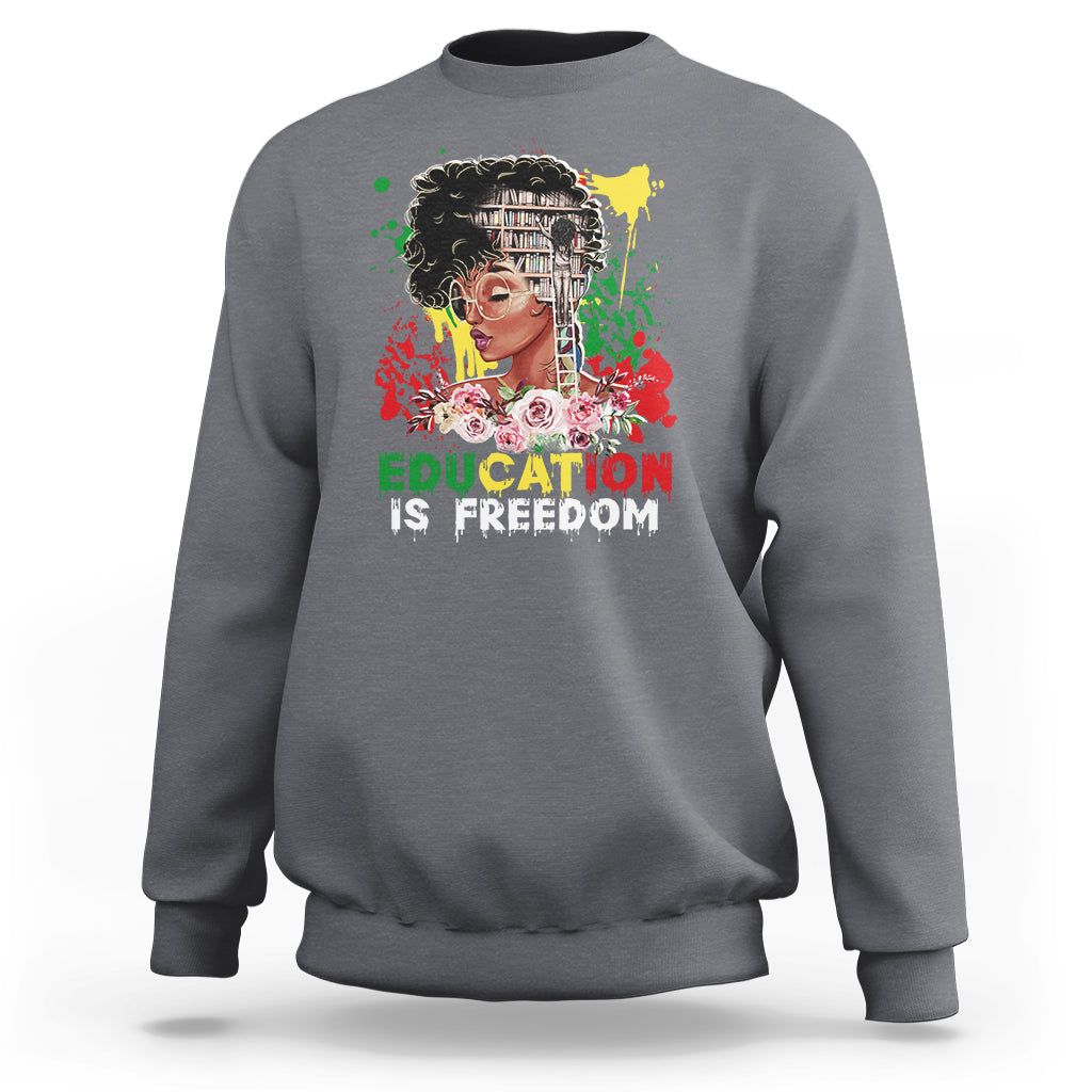 Adult crewneck sweatshirt, light gray, front graphic with face and text “Education is Freedom”.