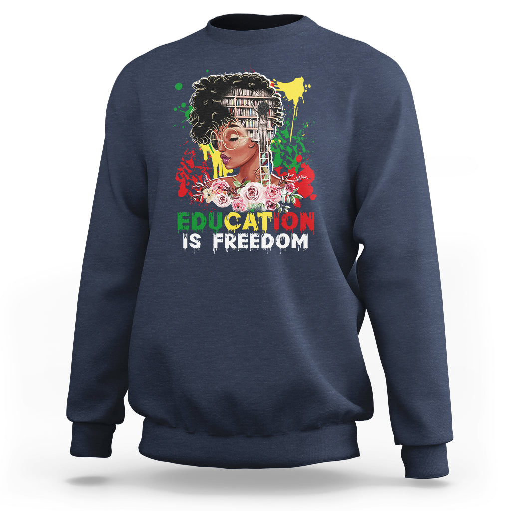 Adult crewneck sweatshirt, navy blue, front graphic with face and text “Education is Freedom”.