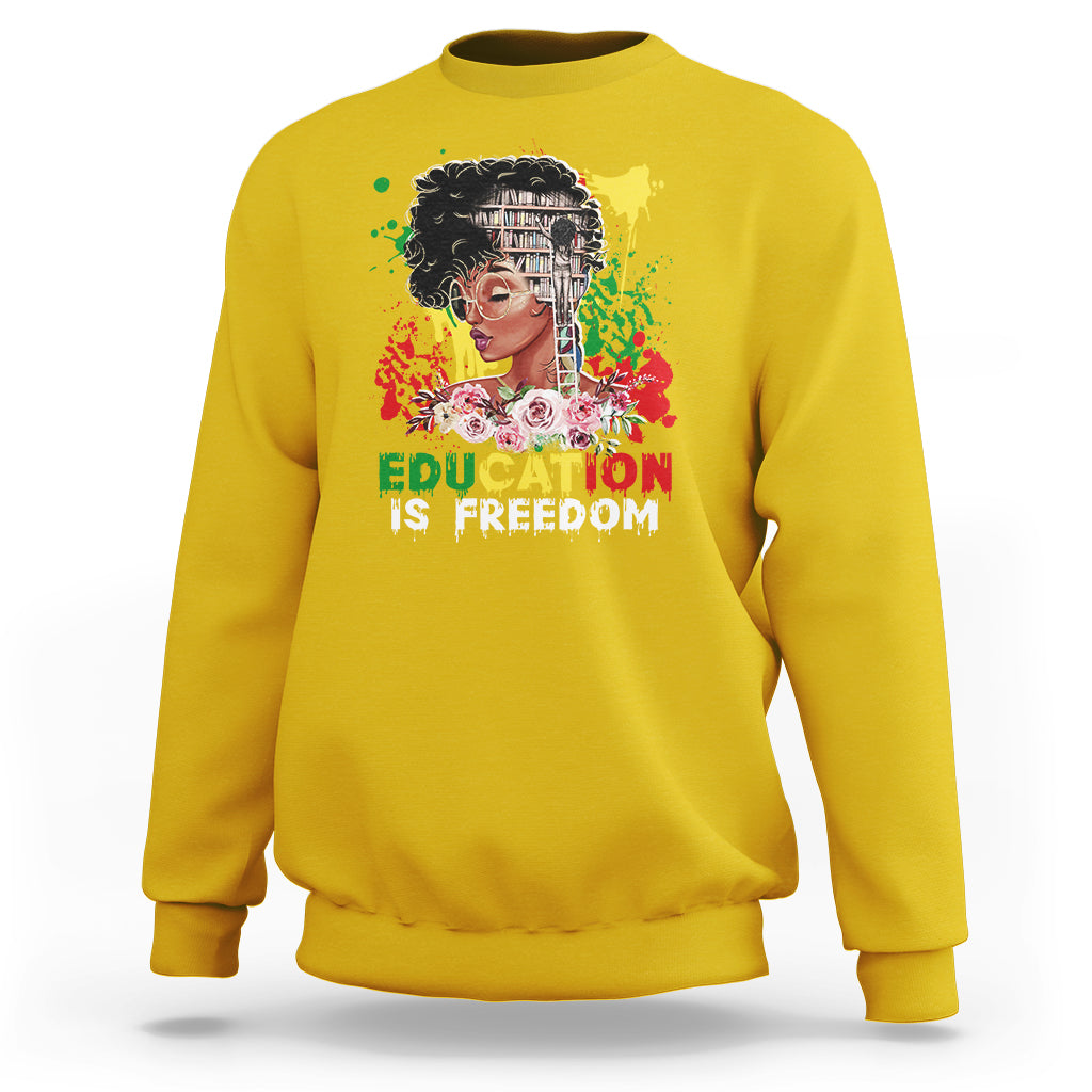 Adult crewneck sweatshirt, yellow, front graphic with face and text “Education is Freedom”.