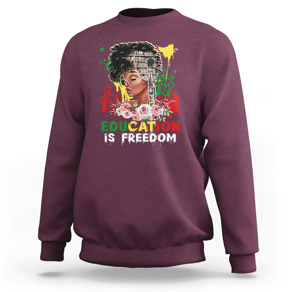 Adult crewneck sweatshirt, maroon, front graphic with face and “Education is Freedom”.