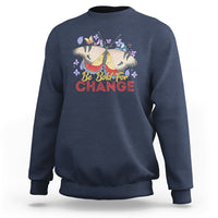 Women's navy sweatshirt with colorful butterfly and “Be Bold for Change” graphic on front