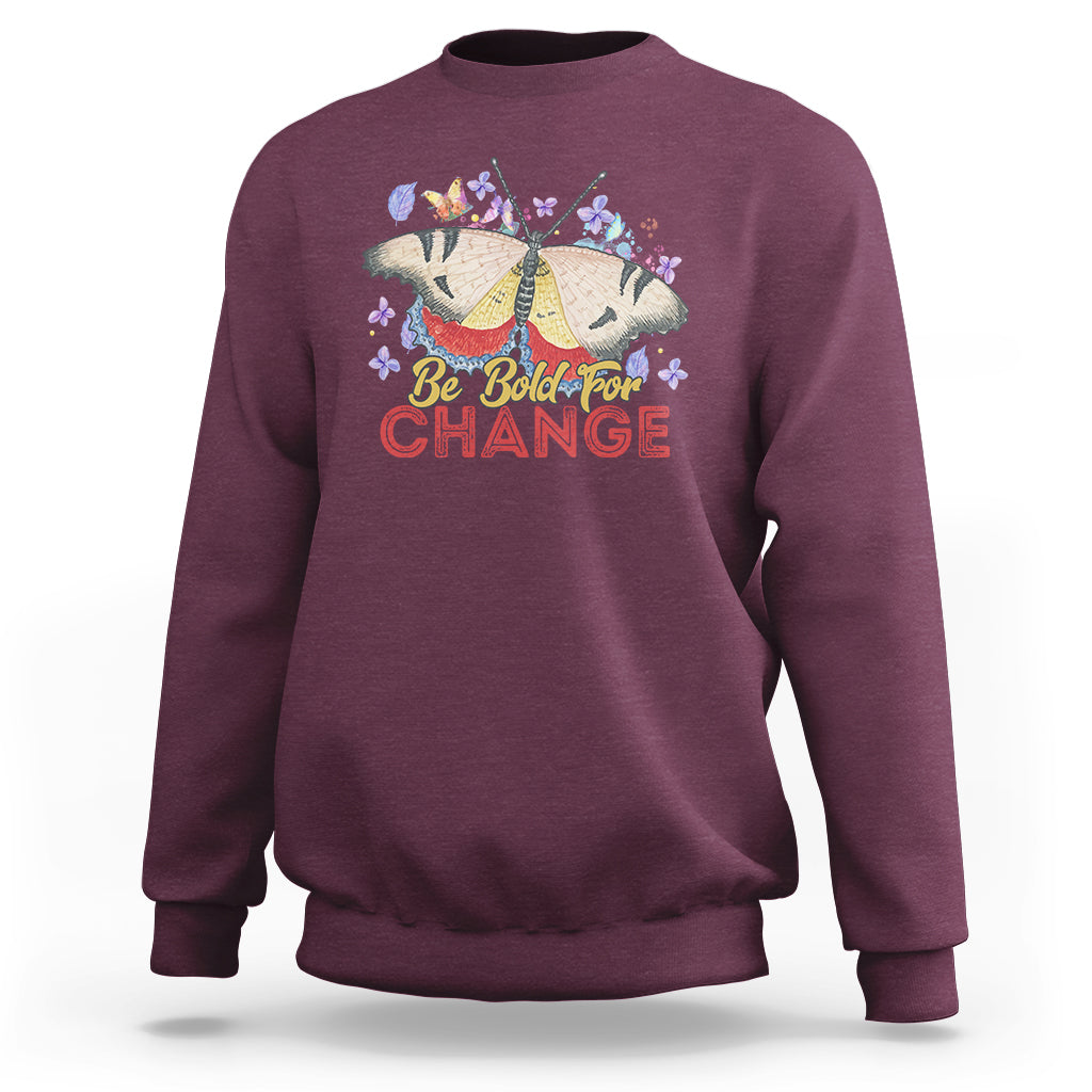 Women's maroon sweatshirt with colorful butterfly and “Be Bold for Change” graphic on front
