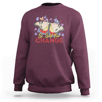 Women's maroon sweatshirt with colorful butterfly and “Be Bold for Change” graphic on front