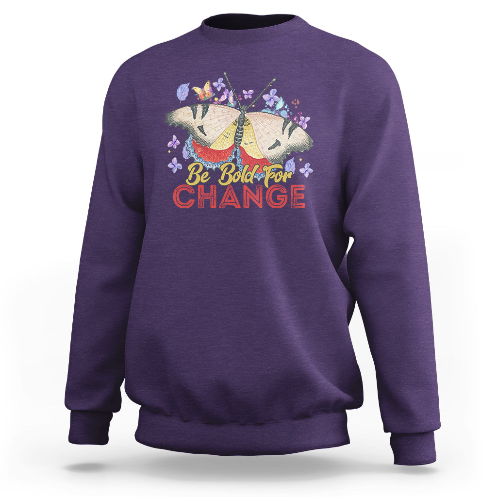 Women's purple sweatshirt with colorful butterfly and “Be Bold for Change” graphic on front