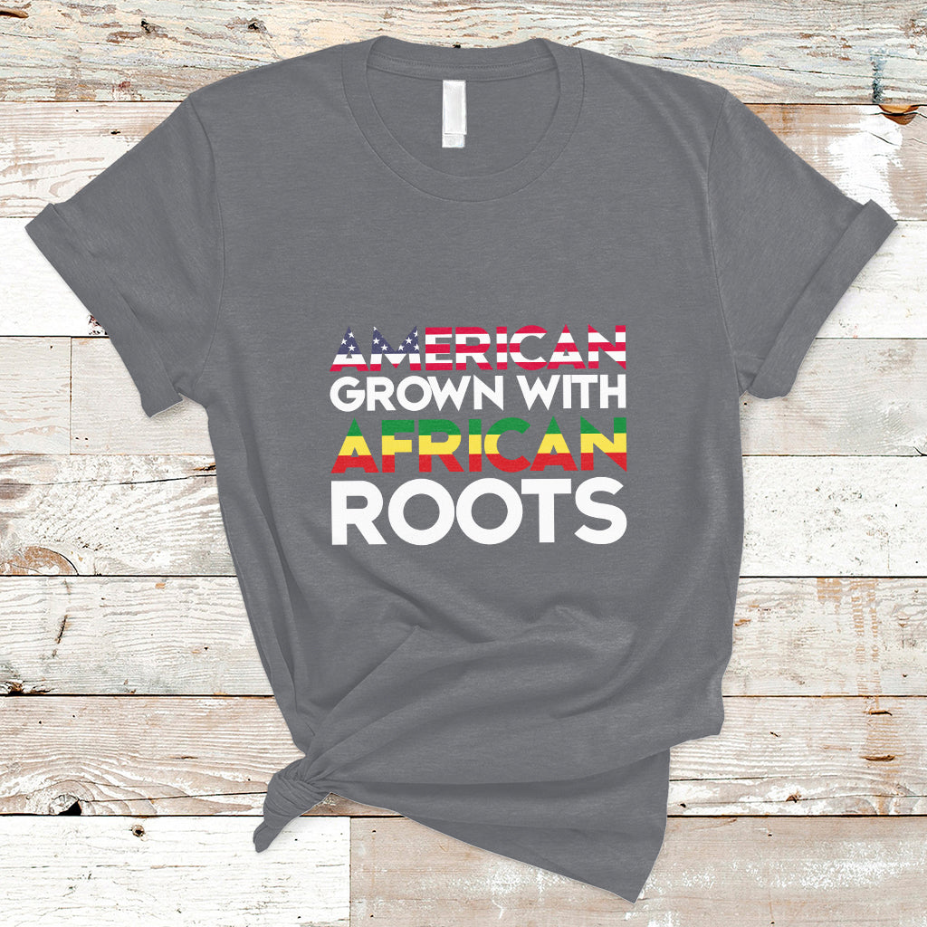 Charcoal gray crew-neck T-shirt with “AMERICAN GROWN WITH AFRICAN ROOTS” front print