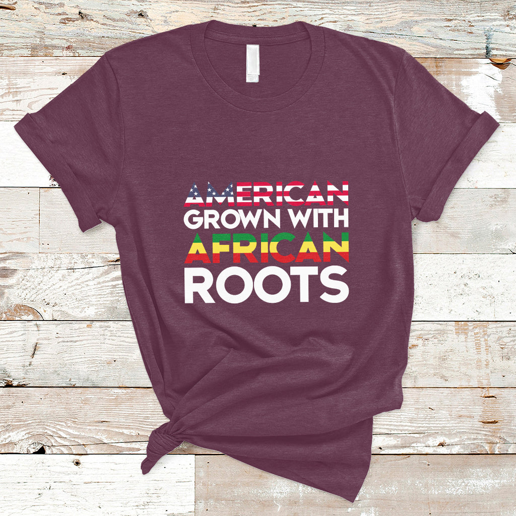 Maroon crew-neck T-shirt with “AMERICAN GROWN WITH AFRICAN ROOTS” front print