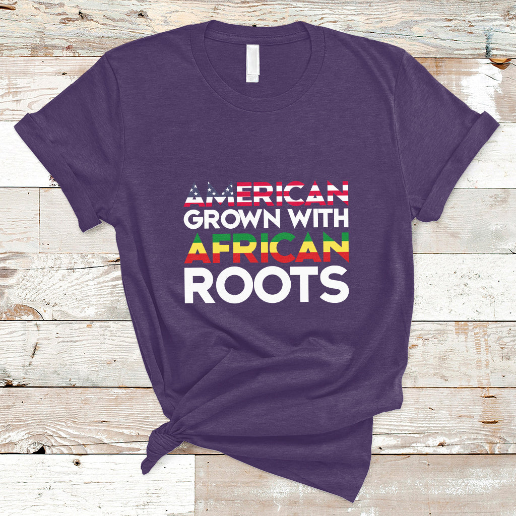 Purple crew-neck T-shirt with “AMERICAN GROWN WITH AFRICAN ROOTS” front print