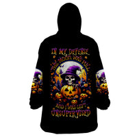 Black wearable blanket hoodie with skull, pumpkins, and witch-themed graphic on back.