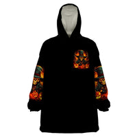Black wearable blanket hoodie with hood, chest witch skull graphic and printed sleeves