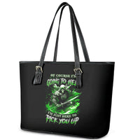 Black tote bag with green skull design, tassel keychain details and double handles.