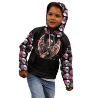 Child wearing black hoodie with hood up, angel skull front print, pink rose-and-skull sleeves.
