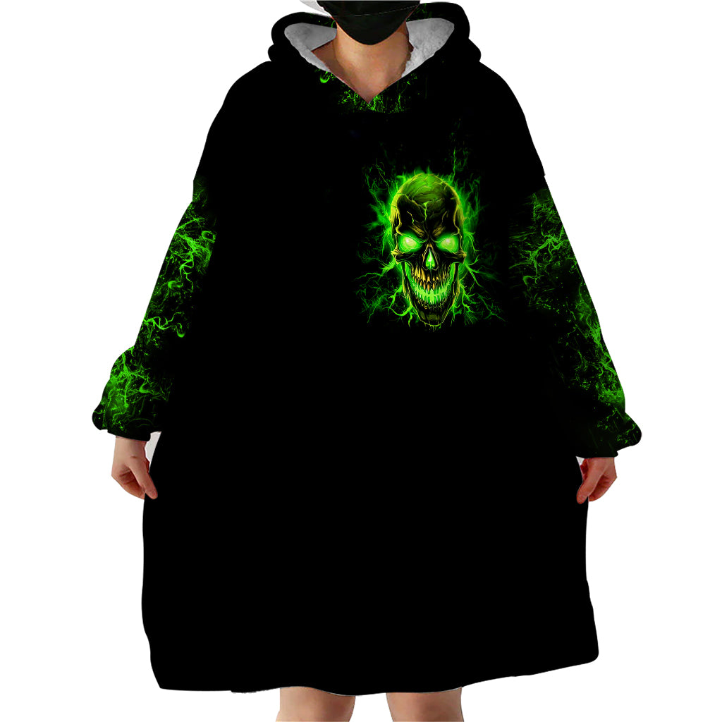 Black hooded wearable blanket hoodie with neon green flame skull graphic and wide sleeves.