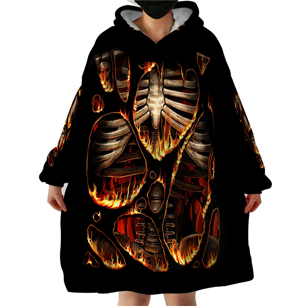 Black skeleton blanket hoodie with hood and large front flame ribcage print, hands visible