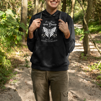 Black hoodie with white moth graphic, front pocket, and drawstring hood, worn outdoors.