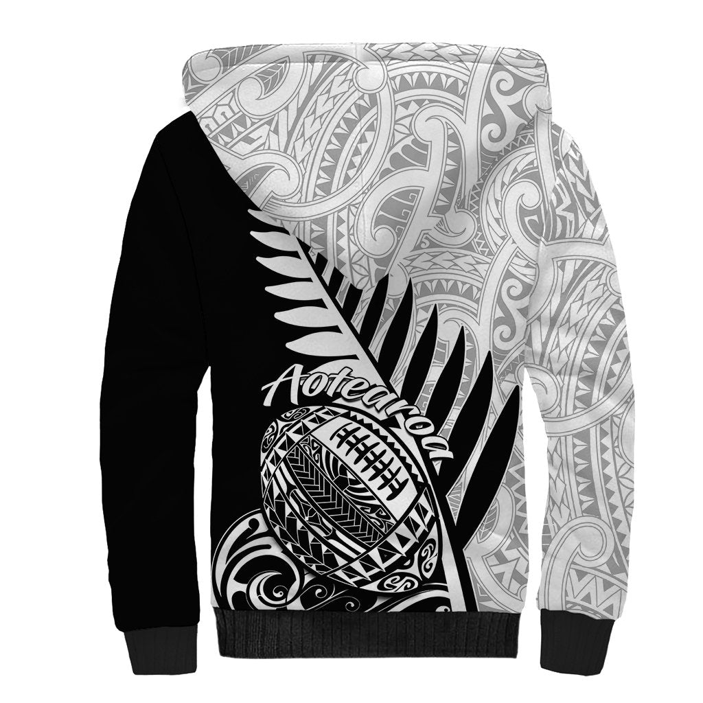 Black and white tribal-print sherpa hoodie with Aotearoa rugby-style graphic on front