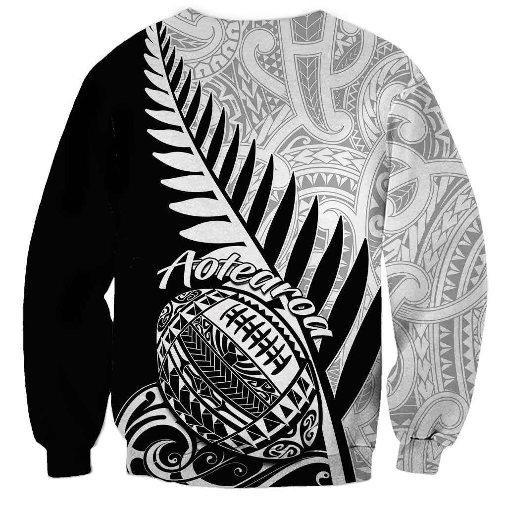 Black rugby sweatshirt back with white Aotearoa text, fern feather art, and football emblem