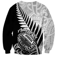 Black rugby sweatshirt back with white Aotearoa text, fern feather art, and football emblem