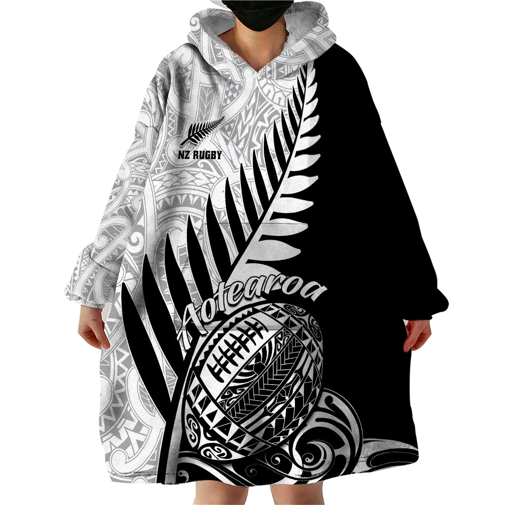 Wearable blanket hoodie with hood, long sleeves, and black-and-white Maori tribal design
