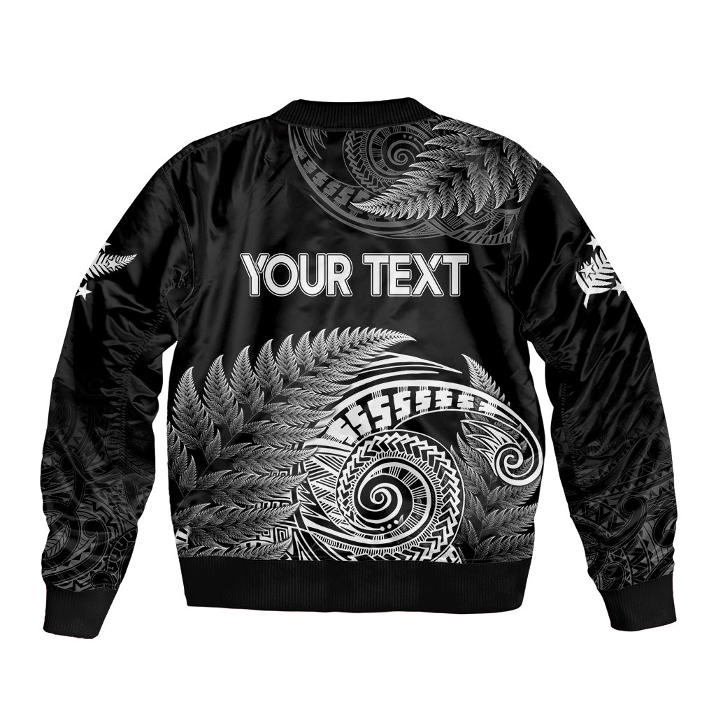 Black bomber jacket with ribbed hem and large white fern spiral graphic on back