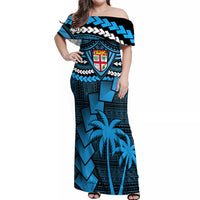 Women’s blue off-shoulder maxi dress with bold tribal shield print and palm motifs