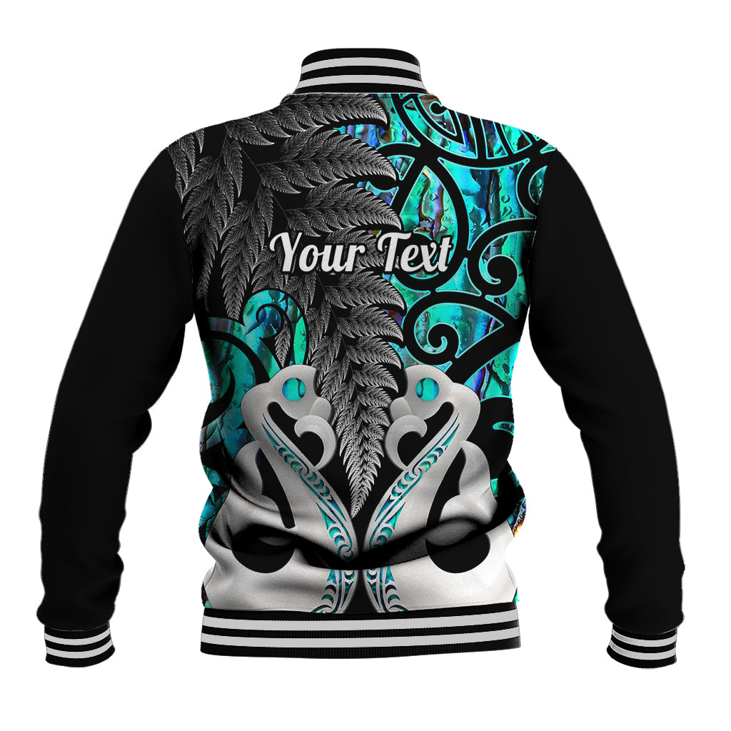 Back of turquoise-and-black baseball jacket with ribbed collar and Maori-style graphic