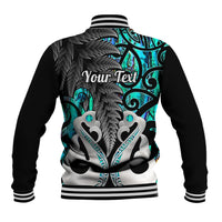 Back of turquoise-and-black baseball jacket with ribbed collar and Maori-style graphic