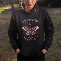 Black hoodie with centered moth graphic and "You Are What You Manifest" text