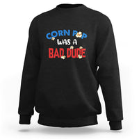 Black sweatshirt with “Corn Pop was a bad dude” graphic on the chest