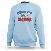 Light blue sweatshirt with “Corn Pop was a bad dude” graphic on the front