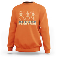 Orange crewneck sweatshirt with dancing skeleton graphic and “IT’S JUST A PHASE” text