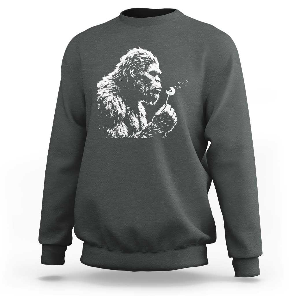 Bigfoot Blowing Dandelion Flower Graphic Sweatshirt Whimsical Sasquatch Profile Artistic Vintage Distressed