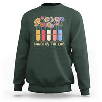Dark forest green crewneck sweatshirt with flower test-tube graphic and 'SAVED BY THE LAB' lettering