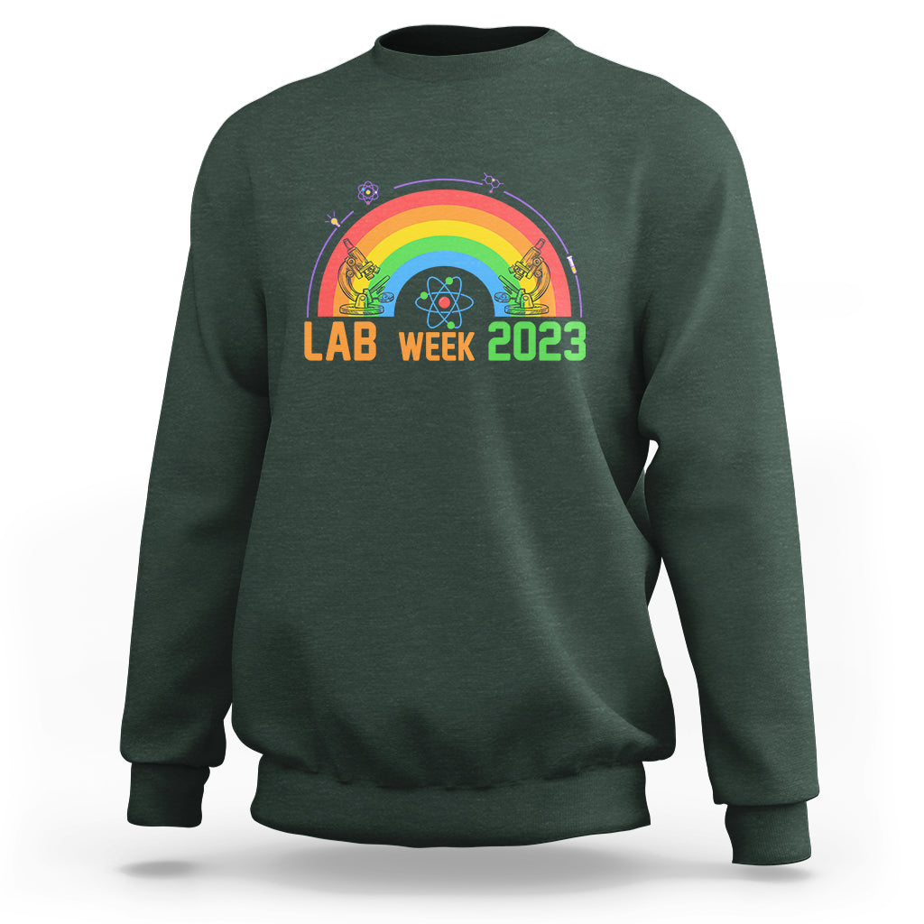 Crewneck lab sweatshirt in dark forest green with Lab Week 2023 rainbow graphic