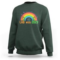 Crewneck lab sweatshirt in dark forest green with Lab Week 2023 rainbow graphic
