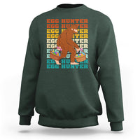 Kids long-sleeve crewneck sweatshirt, dark forest green; Bigfoot egg hunter graphic
