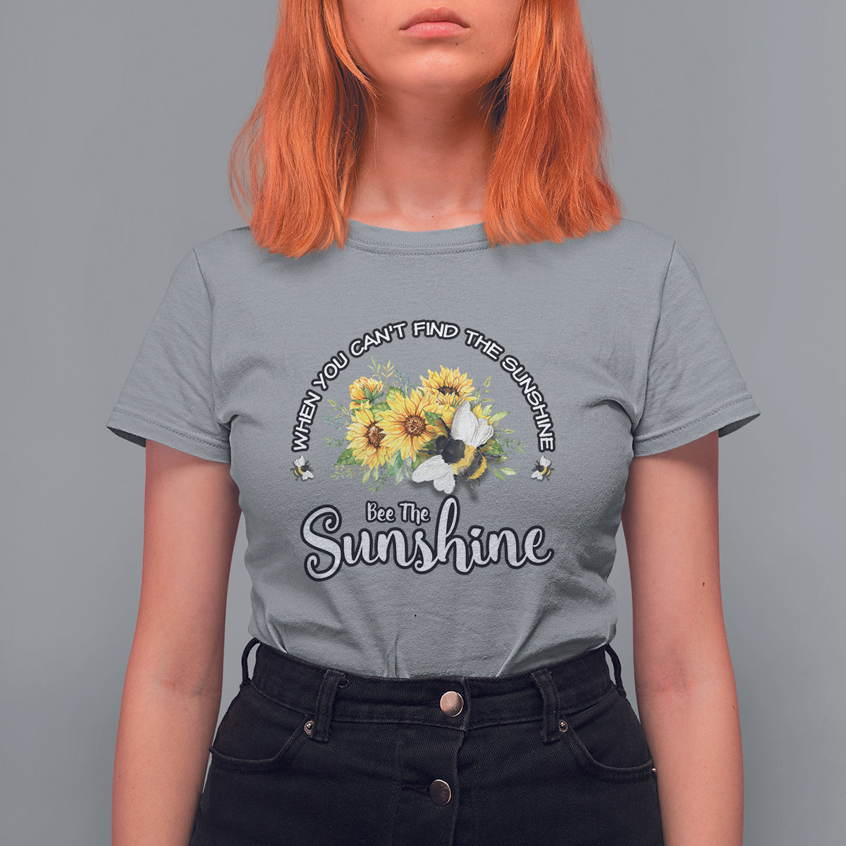 Light gray women’s T-shirt with sunflower and bee graphic, “Bee The Sunshine” slogan