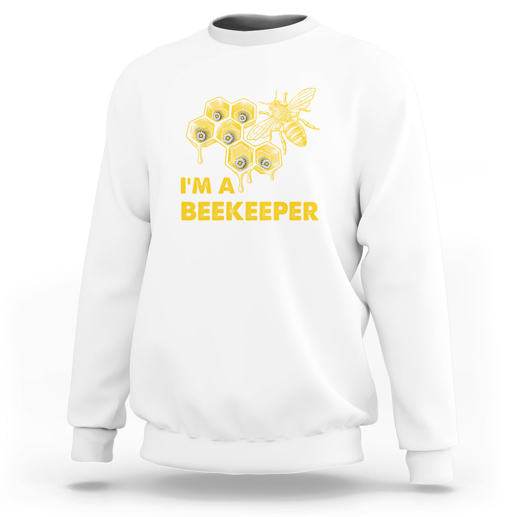 White crewneck sweatshirt with gold honeycomb bee graphic and "I'M A BEEKEEPER" text.