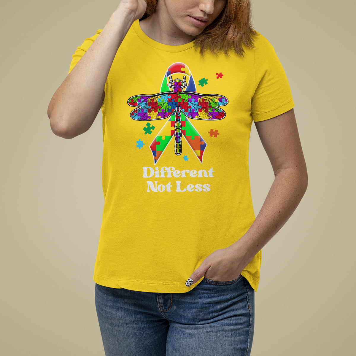 Daisy yellow autism awareness T-shirt with colorful puzzle dragonfly graphic and “Different Not Less”