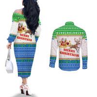 Sierra Leone Christmas Couples Matching Off The Shoulder Long Sleeve Dress and Long Sleeve Button Shirt with Festive Green Pattern, Golden Lion Emblem, and Santa Sleigh Motif - Wonder Print Shop