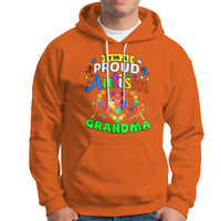 Orange hoodie with colorful “Proud Autism Grandma” graphic and front pocket pouch