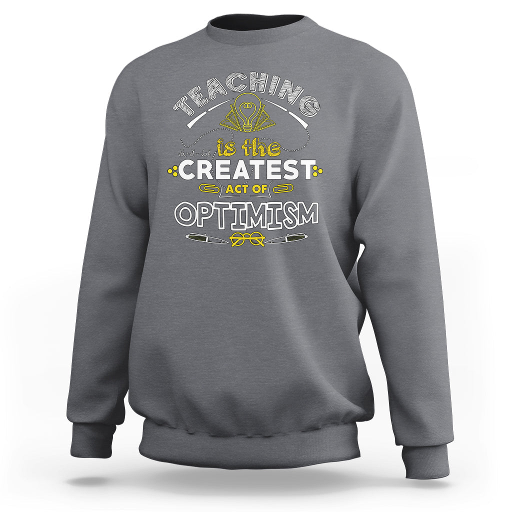 Charcoal gray crewneck teacher sweatshirt with “Teaching is the Greatest Act of Optimism” graphic