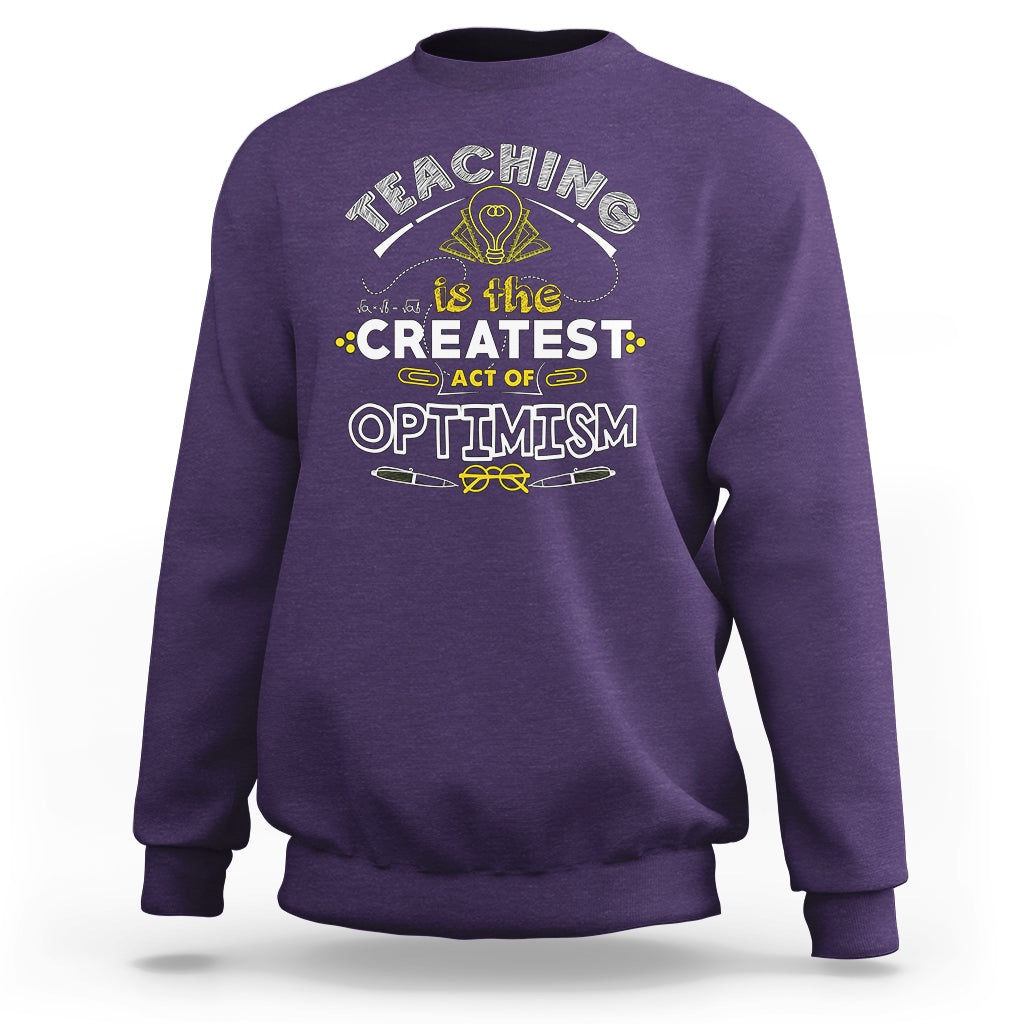 Purple crewneck teacher sweatshirt with “Teaching is the Greatest Act of Optimism” graphic