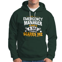 Dark forest green hoodie with “Emergency Manager” dad slogan graphic; kangaroo pocket.